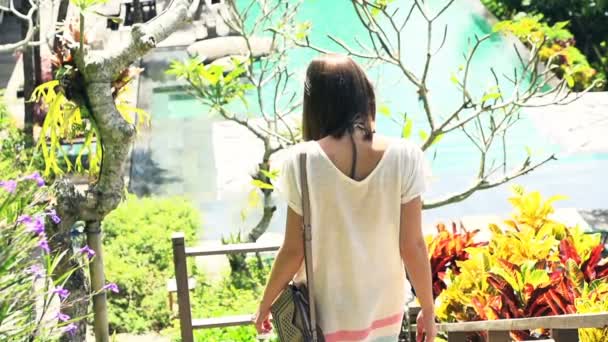 Женщина спускается по лестнице в роскошный сад — стоковое видео