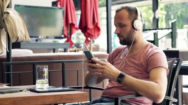 Man listen to music on cellphone with headphones — Stock Video