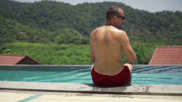 Homem esfriando-se com água da piscina — Vídeo de Stock