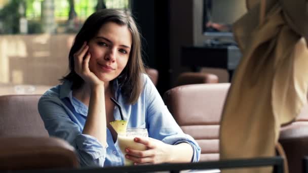 Woman holding cocktail sitting in cafe — Stock Video