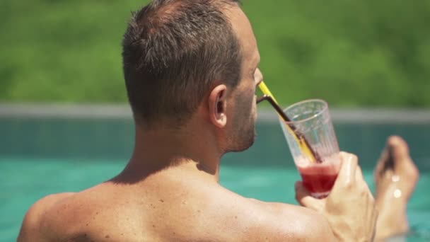 Mann trinkt Cocktail im Schwimmbad — Stockvideo