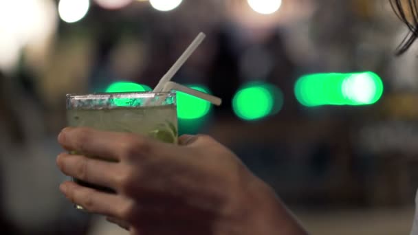 Weibliche Hände trinken Cocktail in der Nacht — Stockvideo