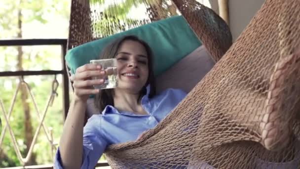 Vrouw drinken en het verhogen van de toast op hangmat — Stockvideo