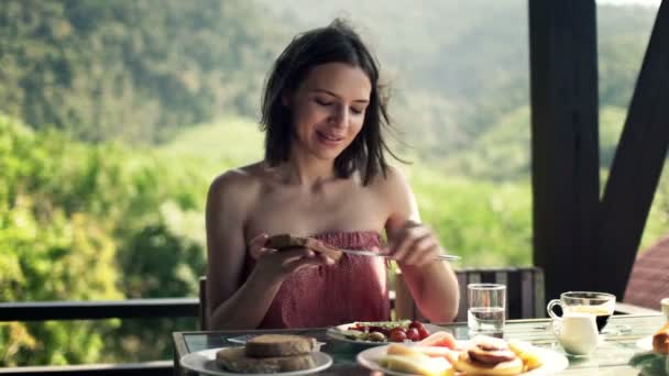 Woman preparing sandwich and eating breakfast — Stock Video