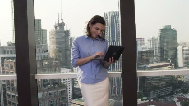 Business woman working on laptop standing on terrace — стоковое видео