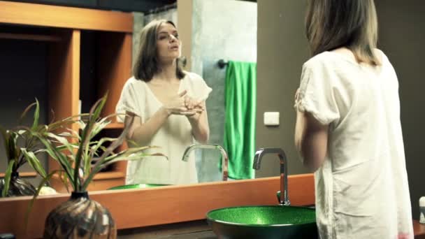 Mujer aplicando crema en su cara — Vídeos de Stock