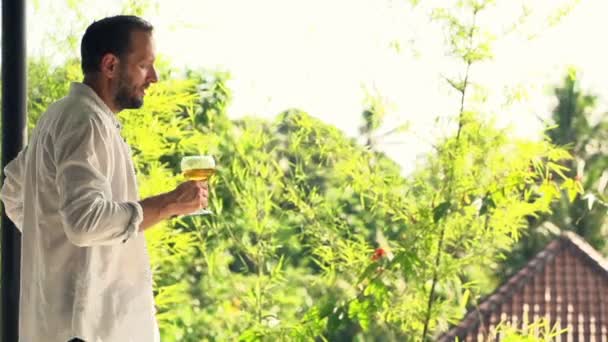 Hombre contento oliendo y bebiendo vino en la terraza — Vídeo de stock