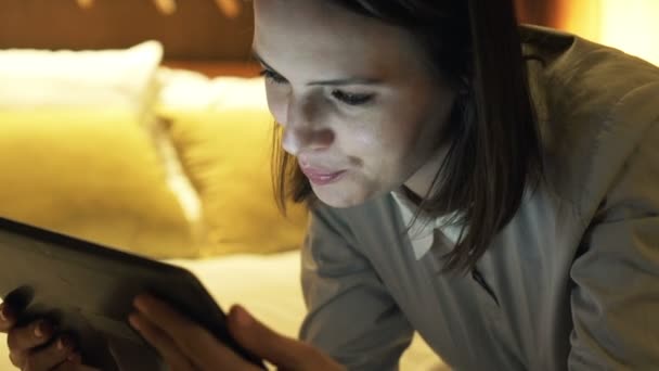 Iş kadını yatakta yatarken dizüstü bilgisayar kullanarak — Stok video