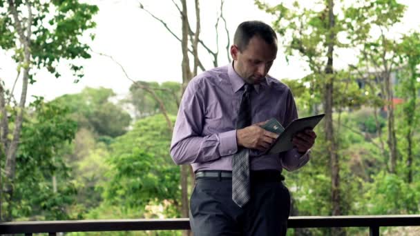 Businessman comparing data on smartphone and tablet computer — Stock Video