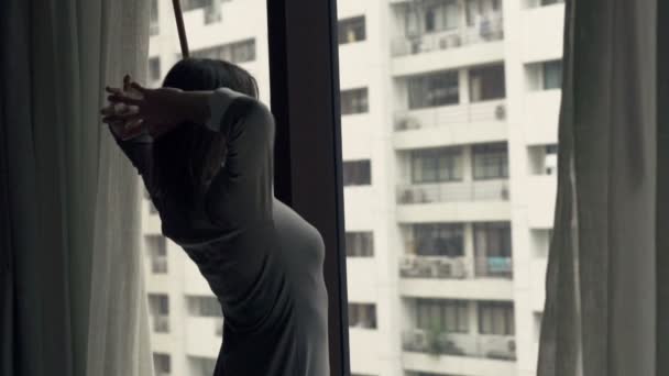 Businesswoman stretching his arms by window at home — Stock Video