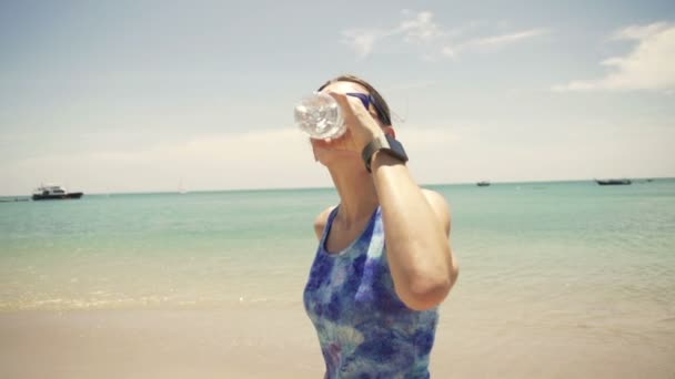 Žena, běžec pitné vody na pláži — Stock video