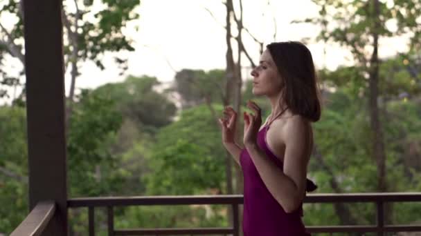 Kvinnan gå ut på terrassen och stretching hennes armar — Stockvideo