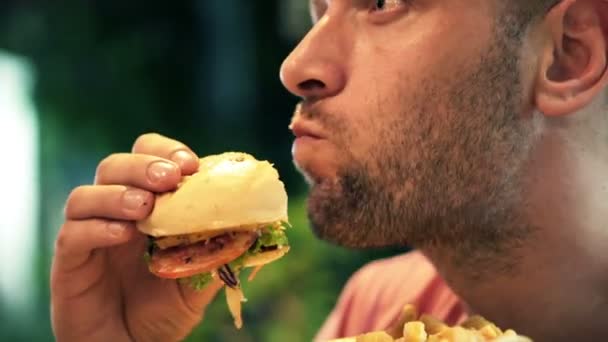 Homem comendo fast food e hambúrguer — Vídeo de Stock