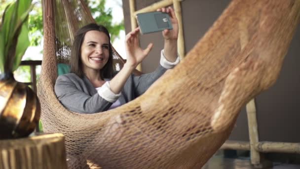 Mujer de negocios tomando foto selfie con teléfono inteligente en hamaca — Vídeos de Stock