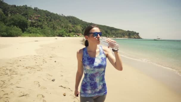 Mujer, corredor de agua potable en la playa — Vídeos de Stock