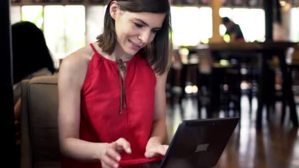 Woman using laptop and drinking coffee — Stock Video