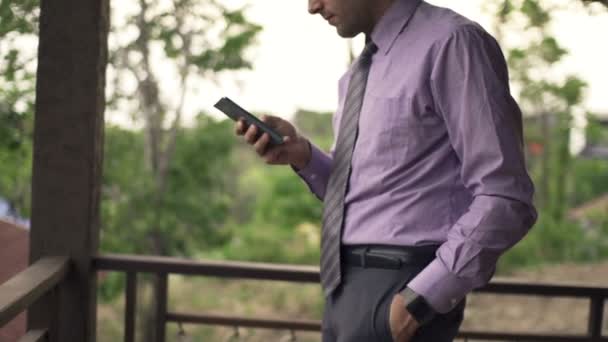 Ung affärsman med smartphone på terrassen — Stockvideo