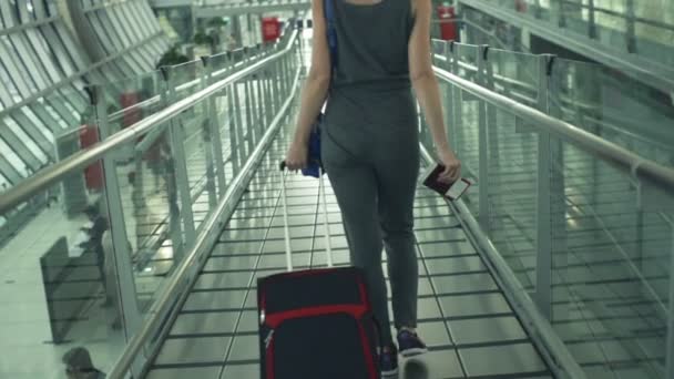 Young woman with suitcase walking at airport — Stock Video