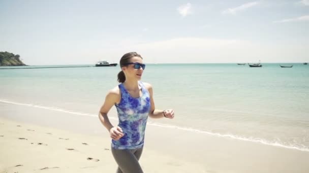 Молодая женщина бежит по красивому пляжу — стоковое видео