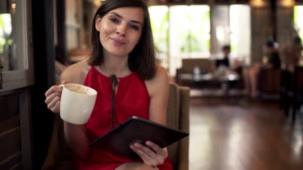 Mujer leyendo en la computadora tableta y beber café — Vídeos de Stock