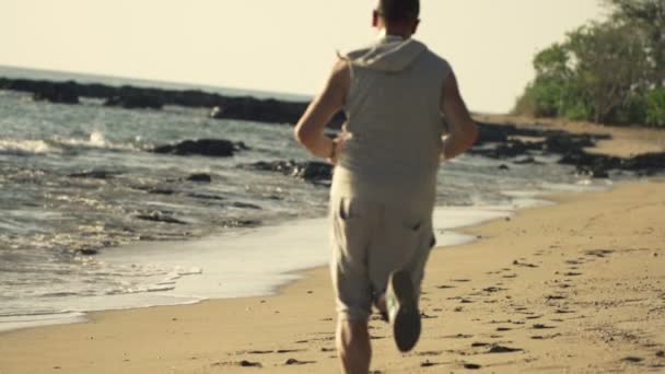 Joven trotando en la playa — Vídeos de Stock