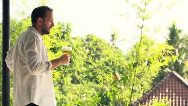 Junger Mann riecht Wein auf Terrasse — Stockvideo