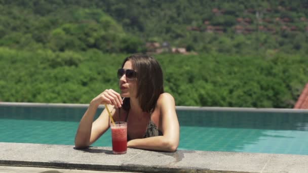 Mulher na piscina relaxante e beber coquetel — Vídeo de Stock