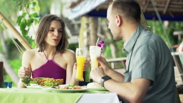 Pareja hablando y levantando tostadas en la cafetería — Vídeo de stock