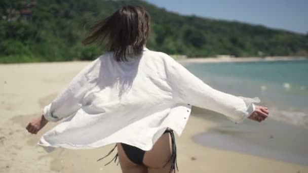 Счастливая женщина, разворачивающаяся на пляже — стоковое видео