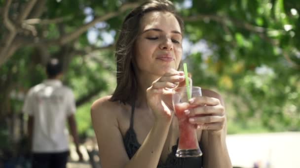 Vrouw tropische cocktail drinken in park — Stockvideo