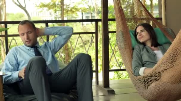 对夫妇谈生意和在露台上放松 — 图库视频影像