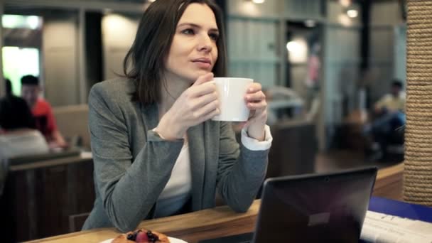 Zakenvrouw koffie drinken en ontspannen in het café — Stockvideo