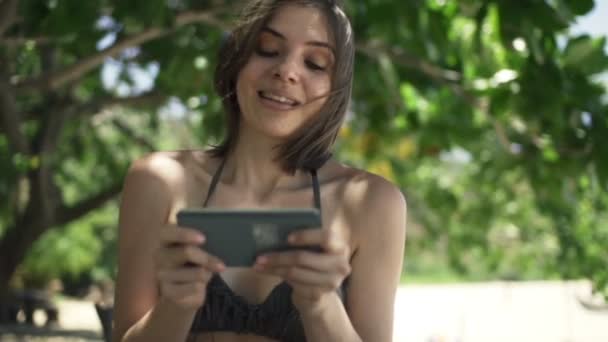 Mujer jugando en el teléfono inteligente en el parque — Vídeos de Stock