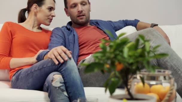 Влюбленная пара целуется дома на диване — стоковое видео
