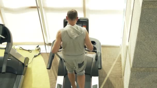 Młody mężczyzna biegający na bieżni na siłowni — Wideo stockowe