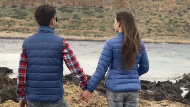 年轻的夫妇握着手 欣赏站在岩石海上的看法 — 图库视频影像