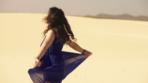 Mulher de vestido azul virando-se no deserto — Vídeo de Stock
