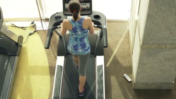Fit femme marche sur tapis roulant dans la salle de gym — Video