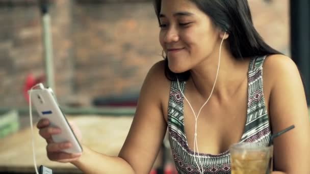 Frau hört Musik mit Handy im Café — Stockvideo