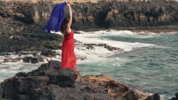 Femme avec pareo debout sur des rochers près de la mer — Video