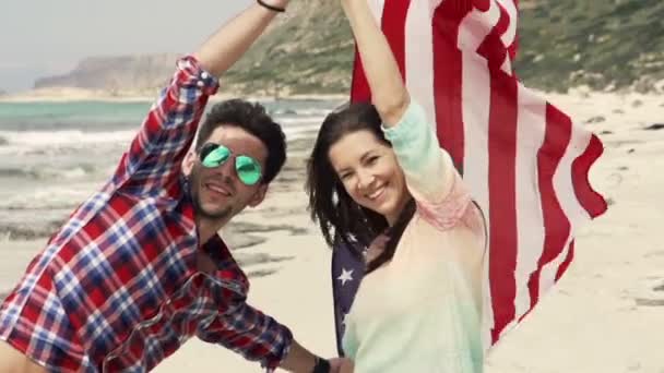 与美国国旗的幸福夫妇的肖像站在海滩近海 — 图库视频影像