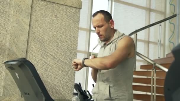 Mężczyzna sprawdzanie tętna na pokładzie smartwatch na bieżni — Wideo stockowe