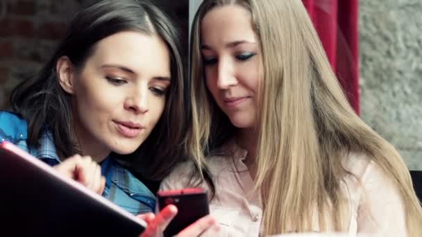 Dos Novias Jóvenes Charlando Través Tableta Teléfono Inteligente Cafetería — Vídeos de Stock