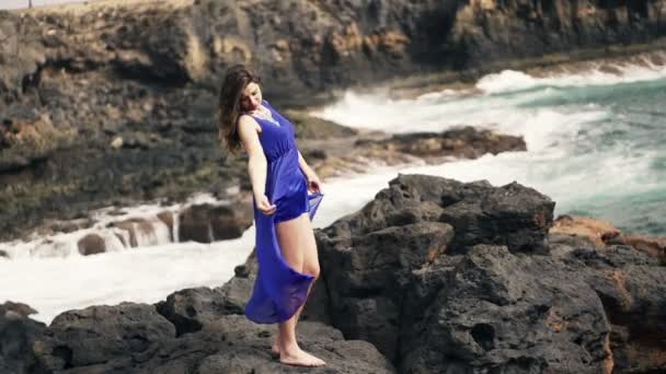 Mujer jugando su vestido en las rocas cerca del mar — Vídeos de Stock