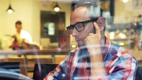 Pensive man sitting in cafe by window — Stock Video