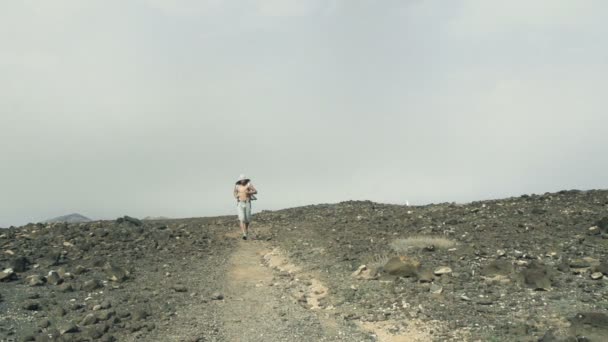 Jovem no capuz correndo no deserto — Vídeo de Stock