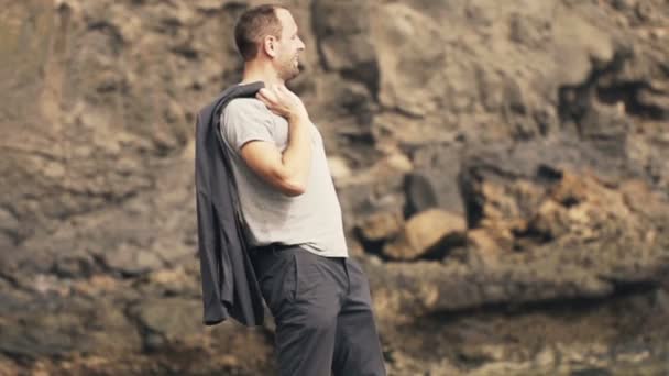 Joven disfrutando, de pie sobre rocas — Vídeo de stock