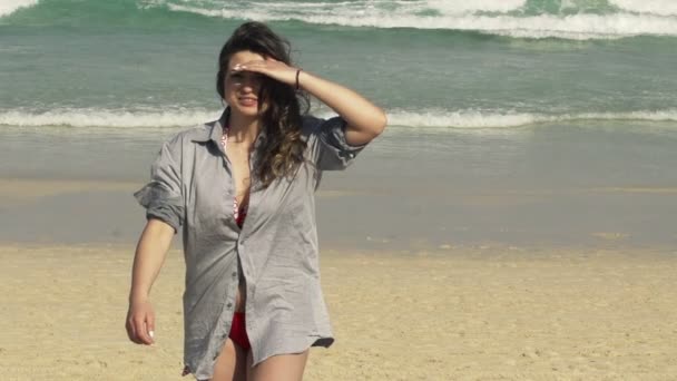 Vrouw in mens shirt wandelen op strand — Stockvideo