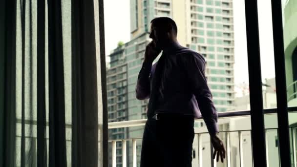 Hombre de negocios enojado hablando por teléfono celular en la terraza — Vídeos de Stock