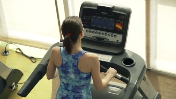 Vrouw draait op loopband machine in sportschool — Stockvideo